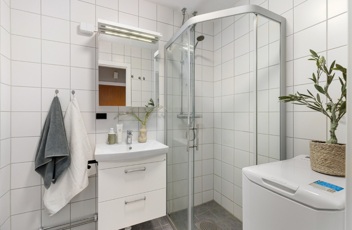 Innbydende flislagt baderom i et tidløst design som ble pusset opp regi av sameiet i 2015.