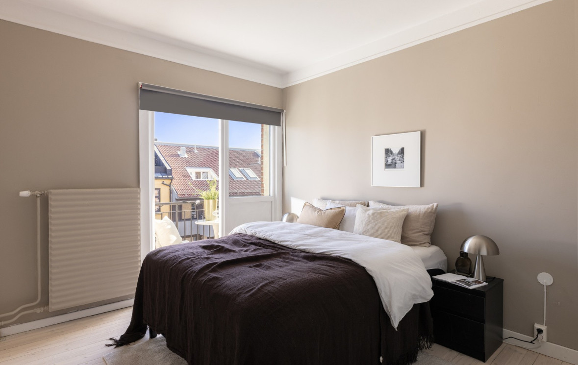 Romslig hovedsoverom med god plass til stor dobbeltseng, nattbord, hjemmekontor og garderobeinnredning.