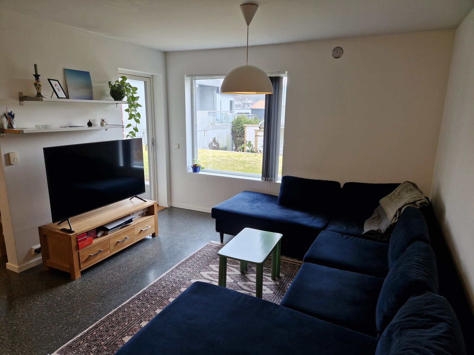 Romslig stue med utgang til stenlagt platting.