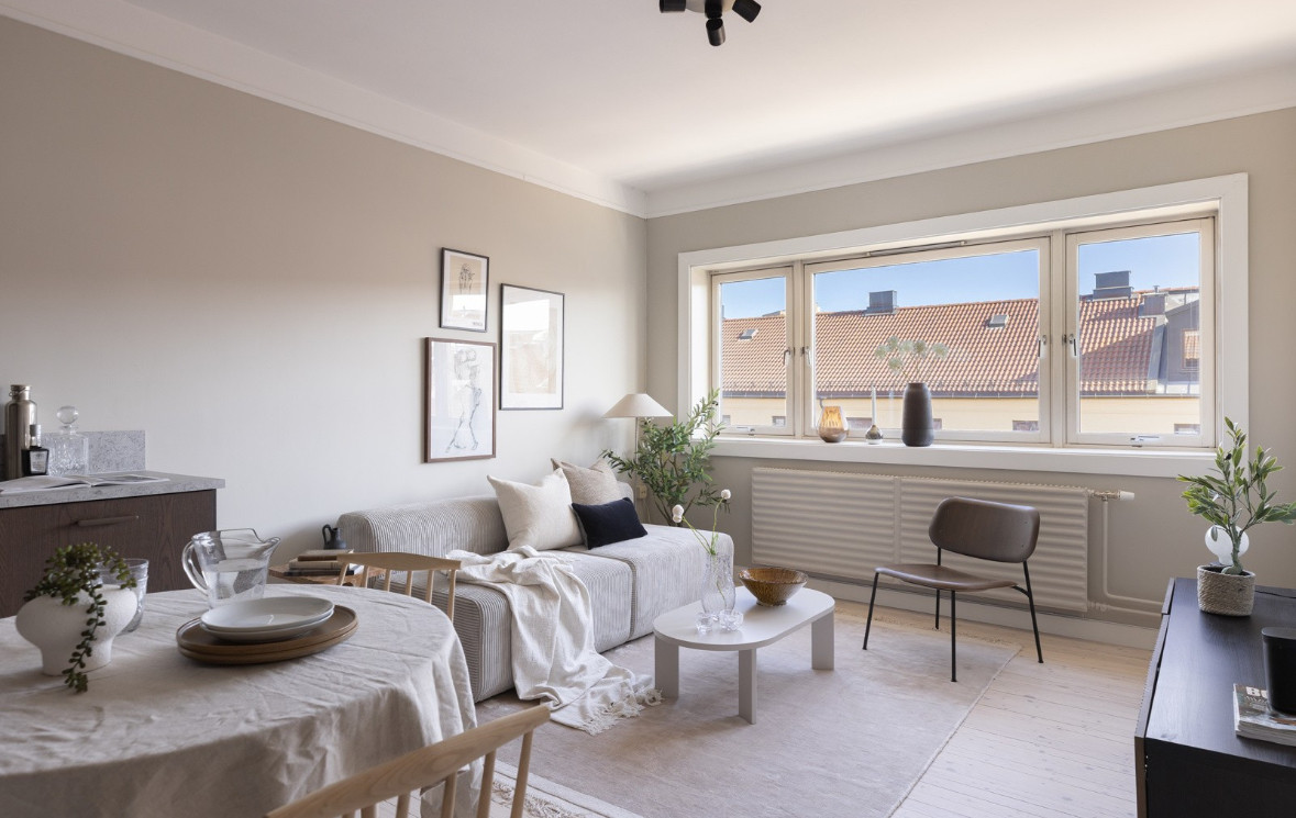 Rommet preges av et lekkert, nyslipt originalt tregulv som er hvitpigmentert og står i herlig harmoni til de myke, beige veggflatene.