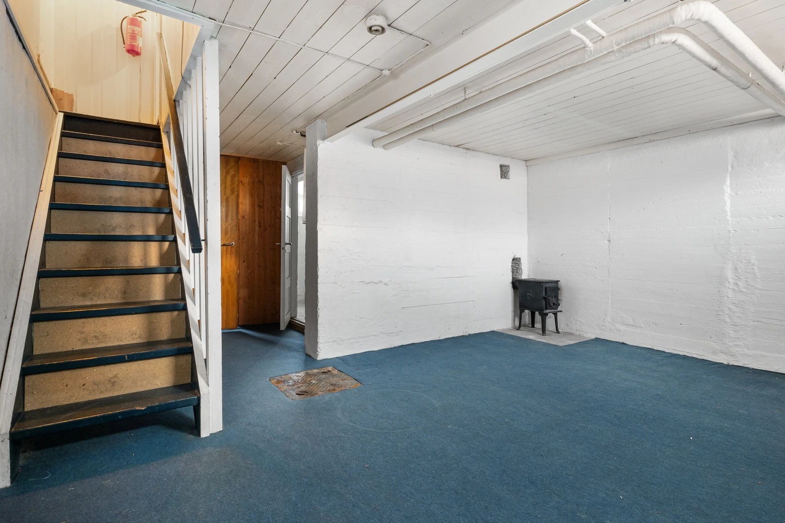 Trapp ned til kjellerstua med peis. Vaskerom til høyre.
