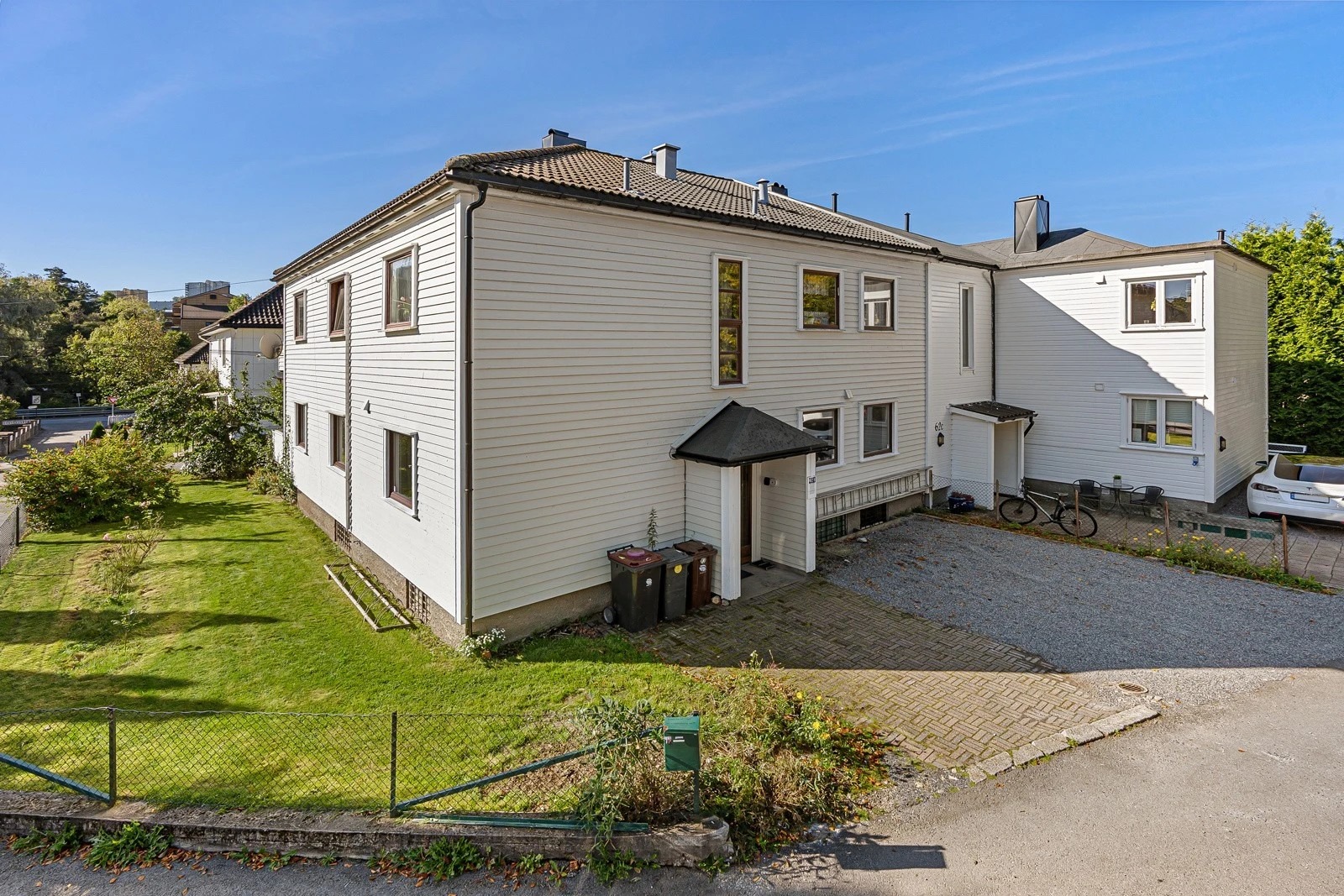 Deler av plenen på bildet er idag opparbeidet til gruslagt parkeringsplass