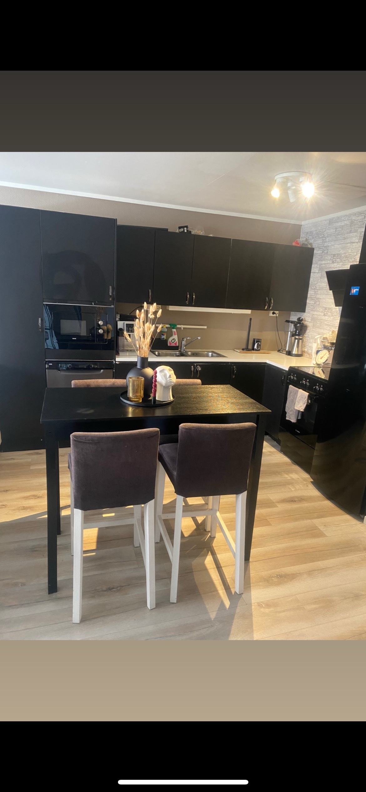 Åpen stue/kjøkken løsning. Sofa med tv er til venstre for bildet.