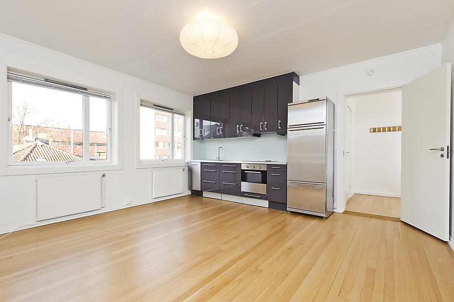 Åpen stue & kjøkkenløsning i et hjørnerom med gode lysforhold.