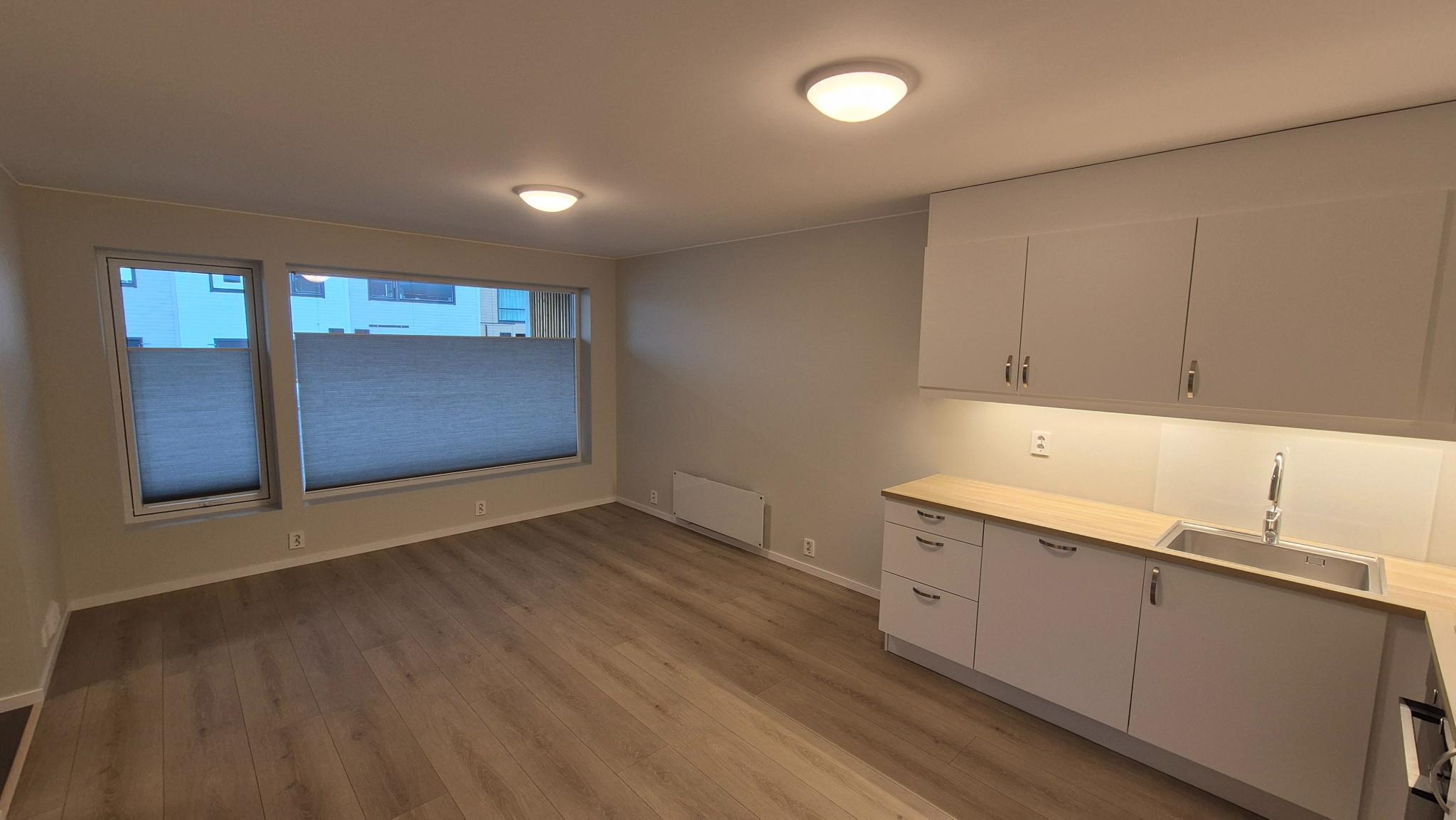 Ca. 21 m2: Stue/kjøkken. Store vindusflater. Doble plissegardiner.