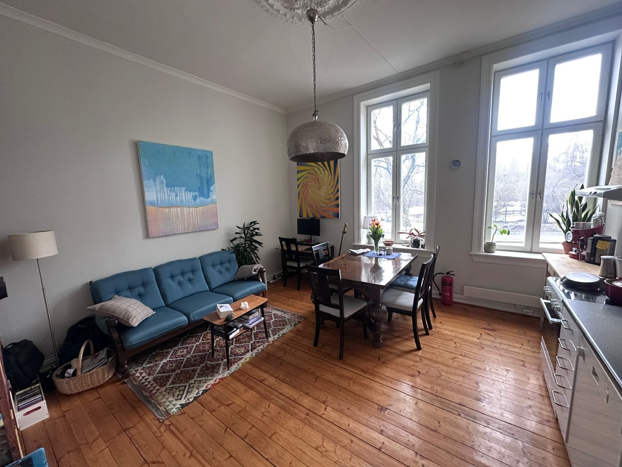 Stue/kjøkken med god takhøyde og store vinduer 