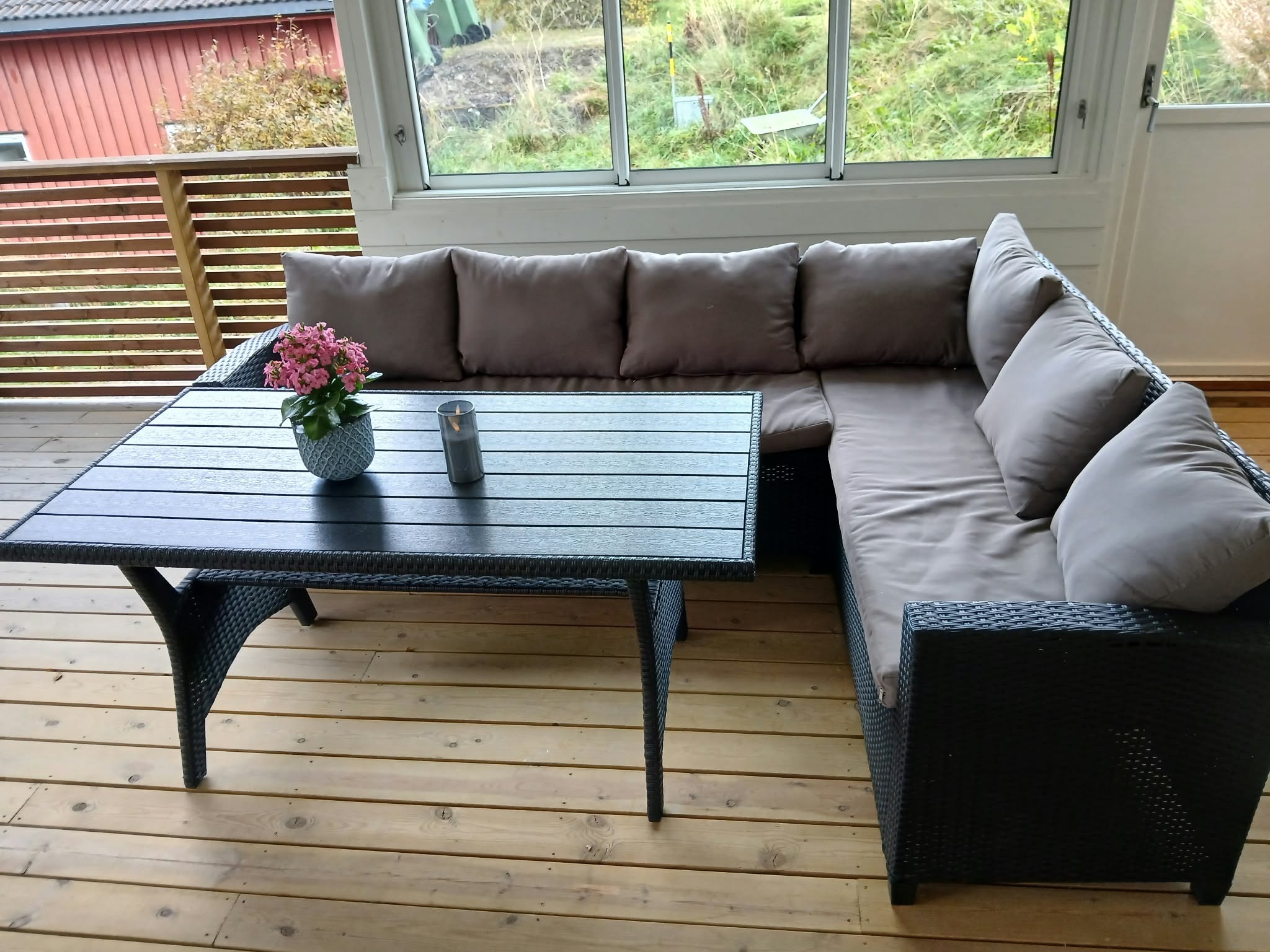 Stor flott veranda med utsikt og delvis innglassing.