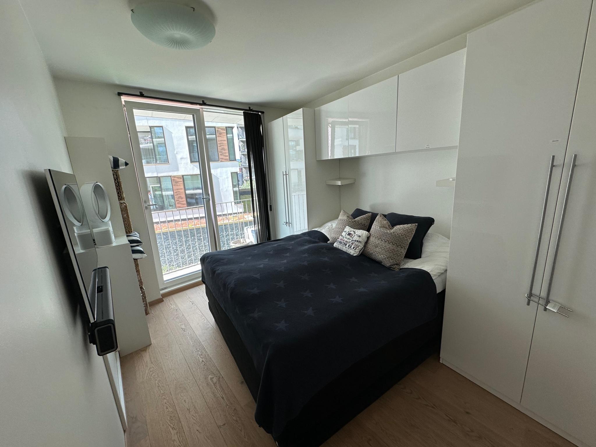 Main bedroom with king-size Svanen top model bed, Samsung TV, dyson ventilator and Sonos soundsystem. Connected to the walk-in-closet and bathroom. 