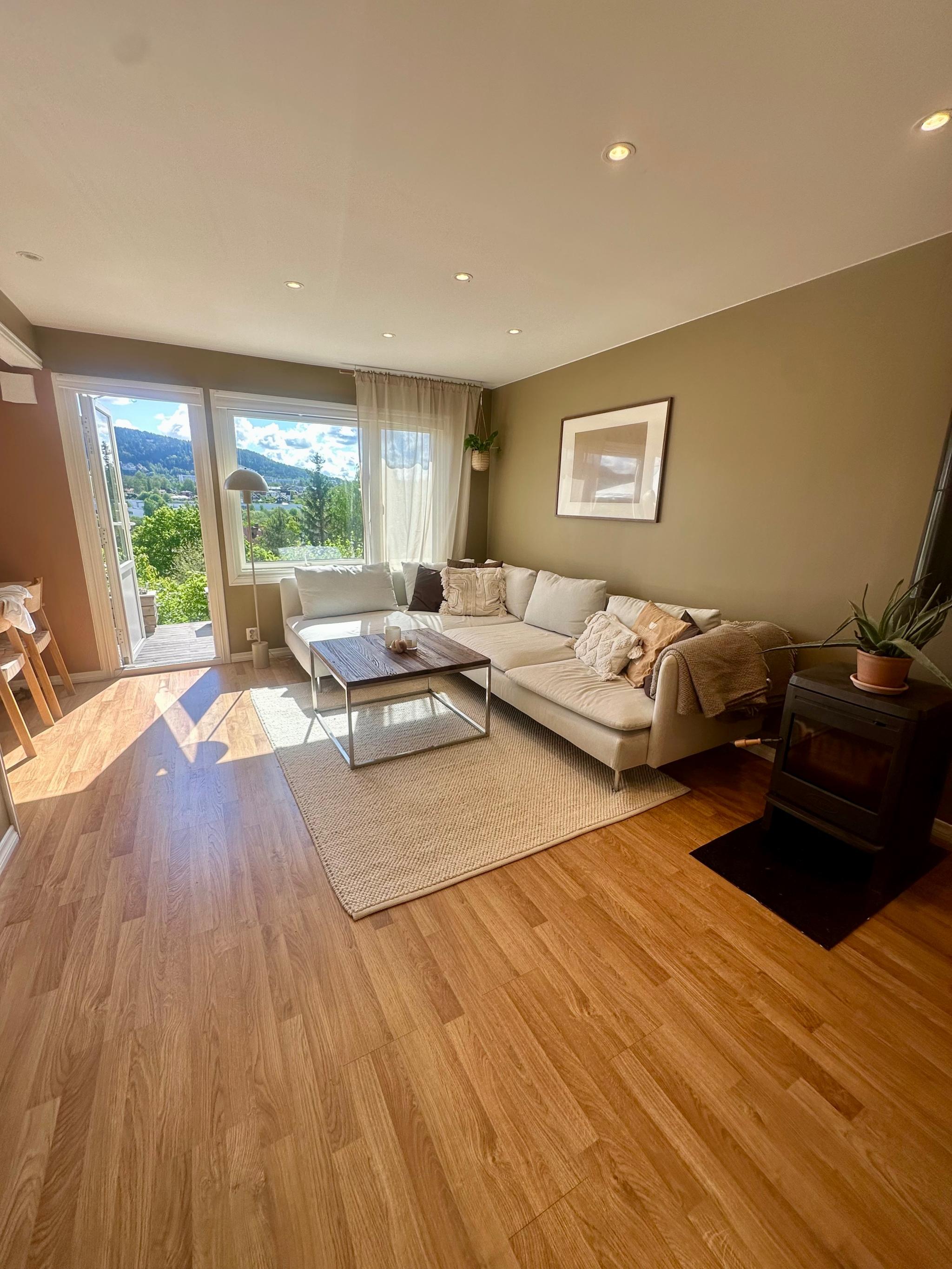 Stor og lys stue med dør direkte ut til markaterrassen 