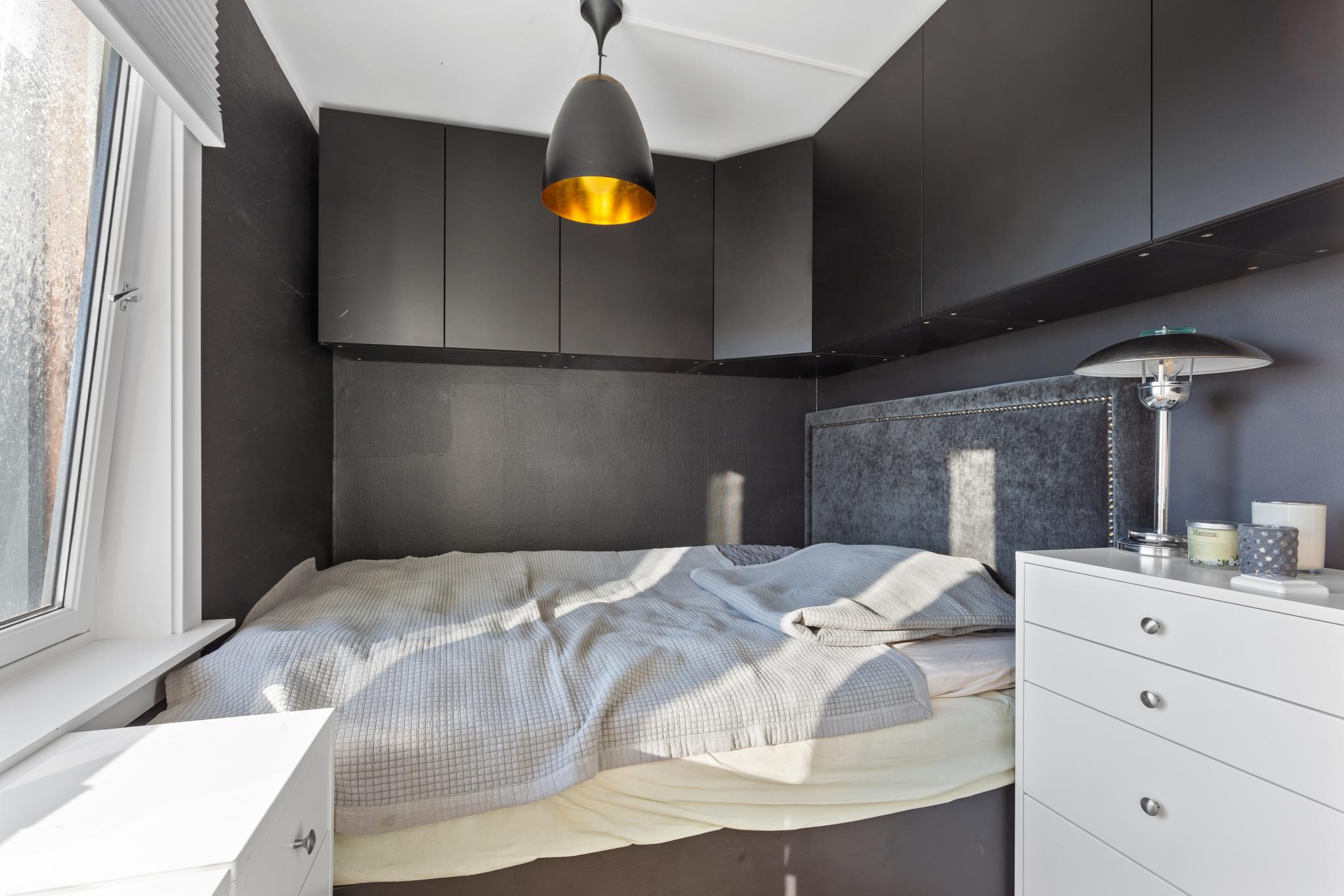 Soverom med plassbygd seng og skap. 