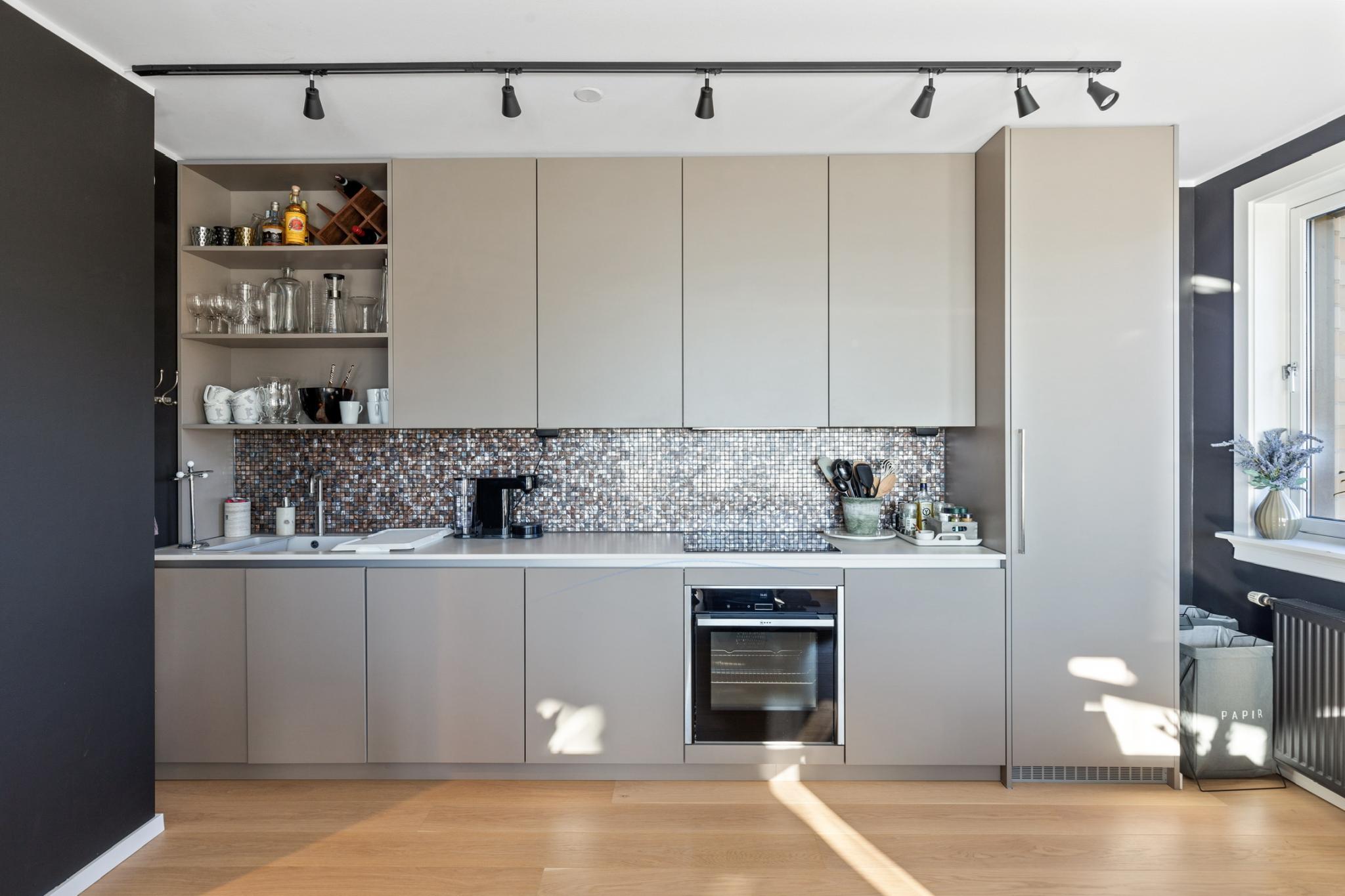 Stilfullt kjøkken med integrerte hvitevarer. 