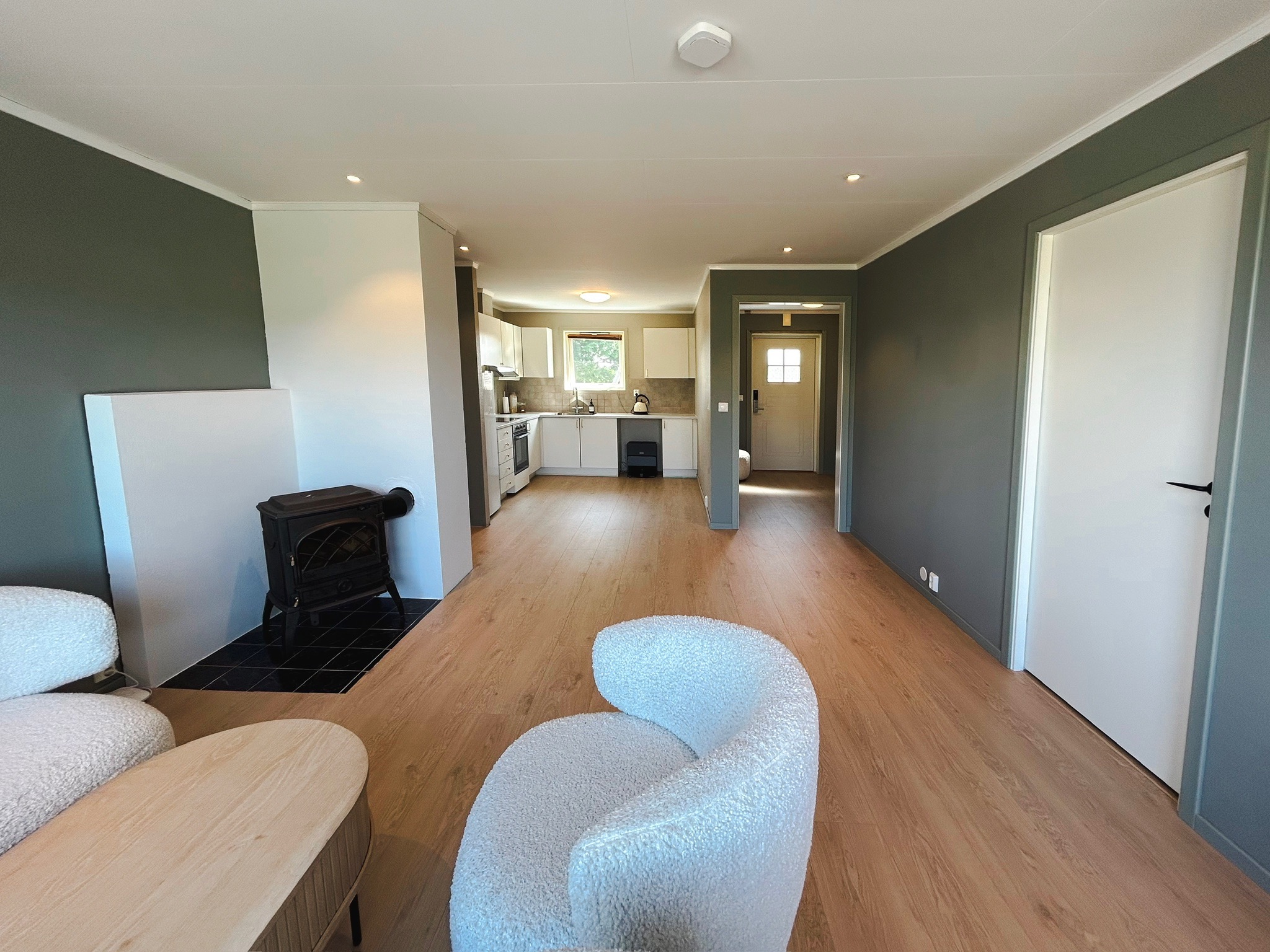 Luftig og åpen stue-/kjøkkenløsning med tilgang til hovedsoverom til høyre 