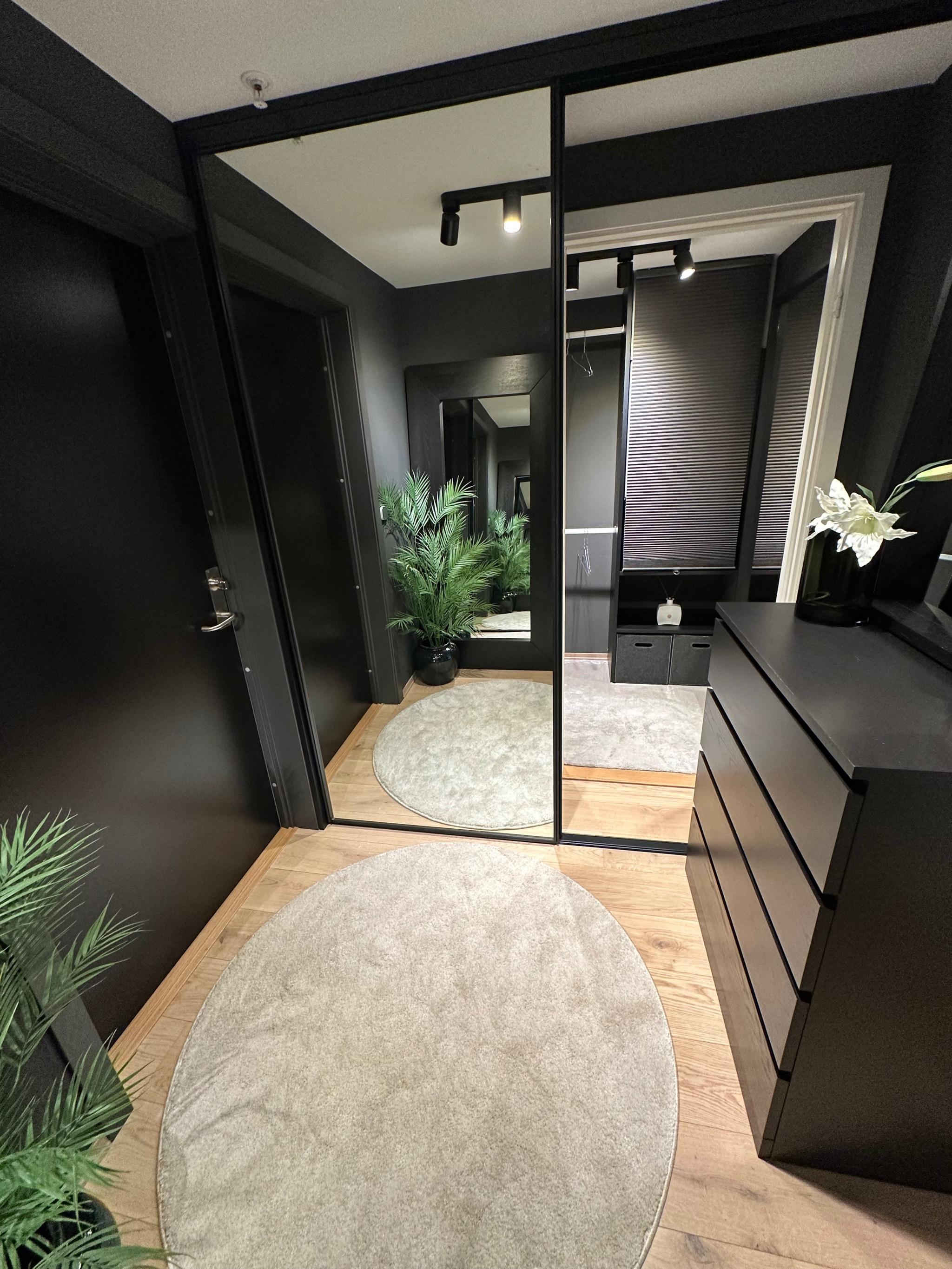 Gang med store skyvedører i speil som deler av inngang til walk in closet.