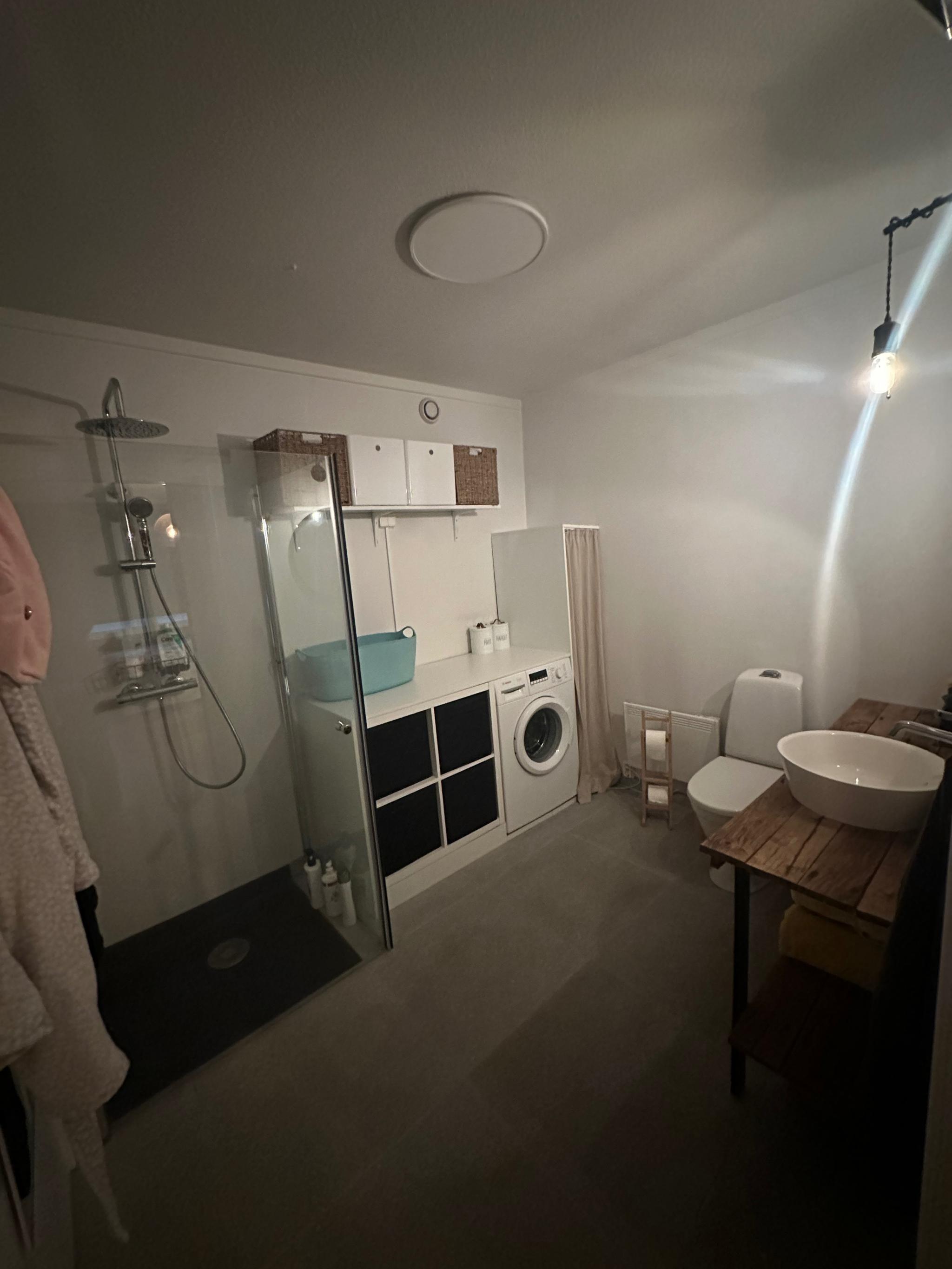 Romslig bad med vaskemaskin, dusj, toalett, servant og masse oppbevaring.