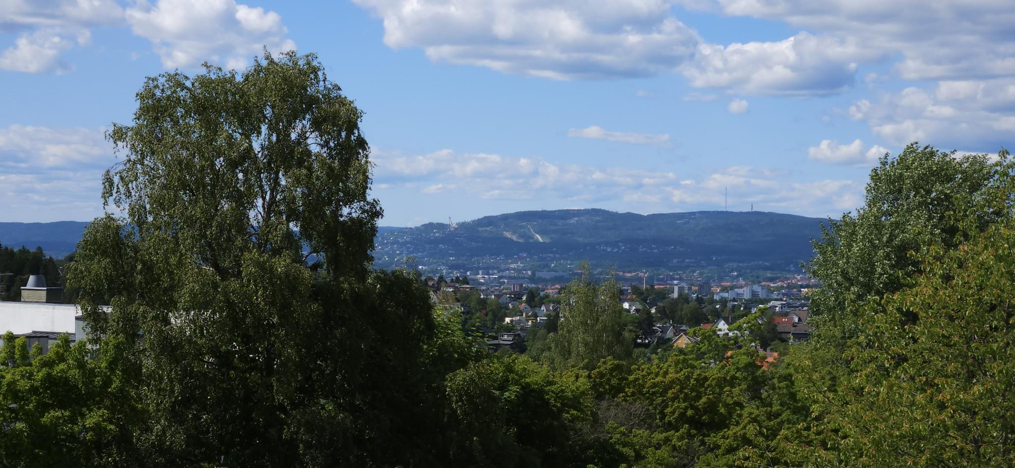 Utsikt mot Holmenkollen og Grefsenkollen. Solnedgang mellom Hk og Gk.
