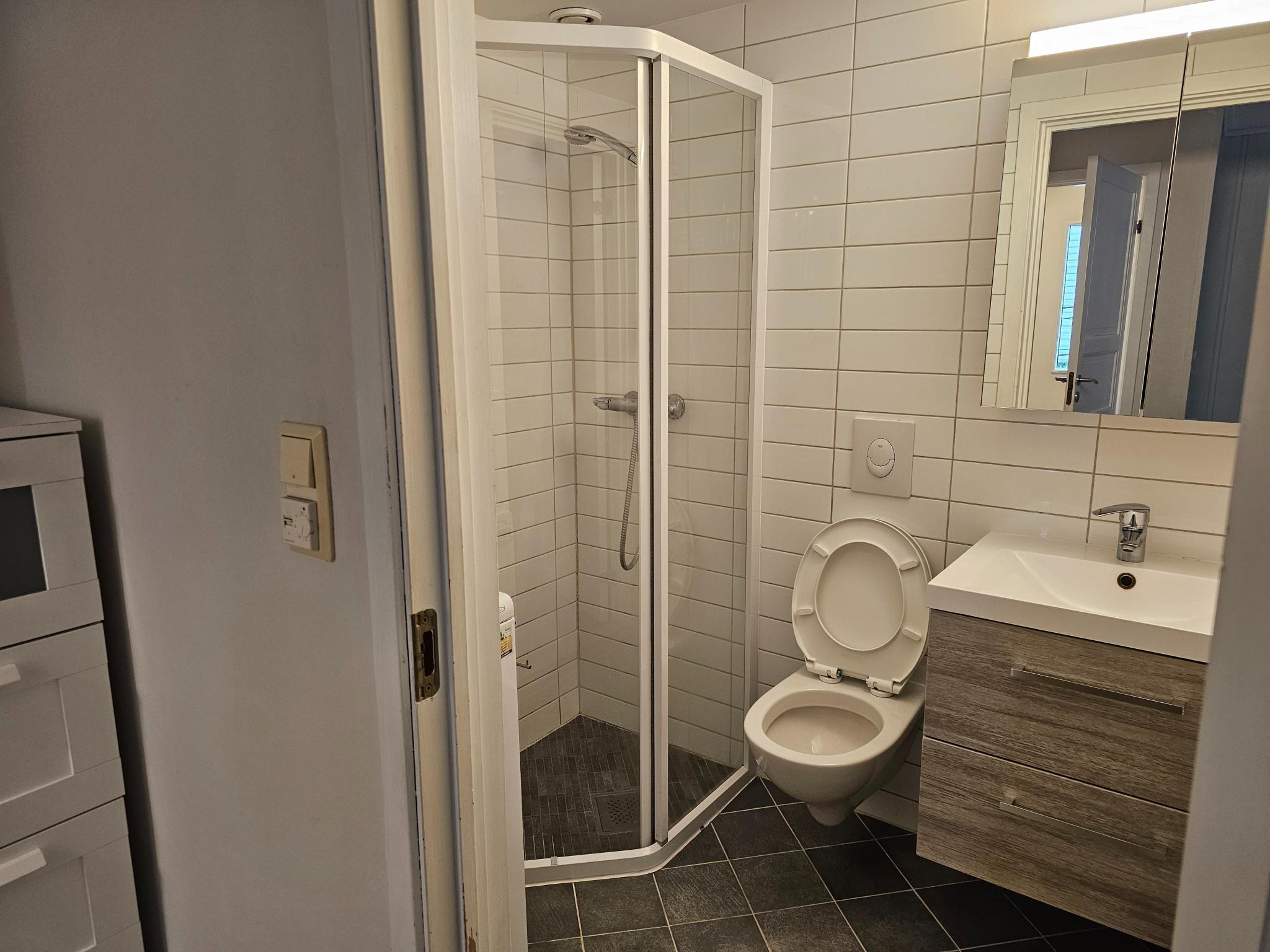 Bad med vaskemaskin, dusj og vegghengt toalett