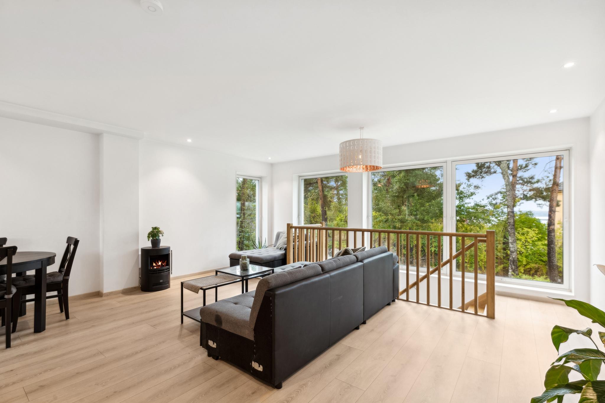 Stor stue med sjøgløtt fra store vinduer med screens