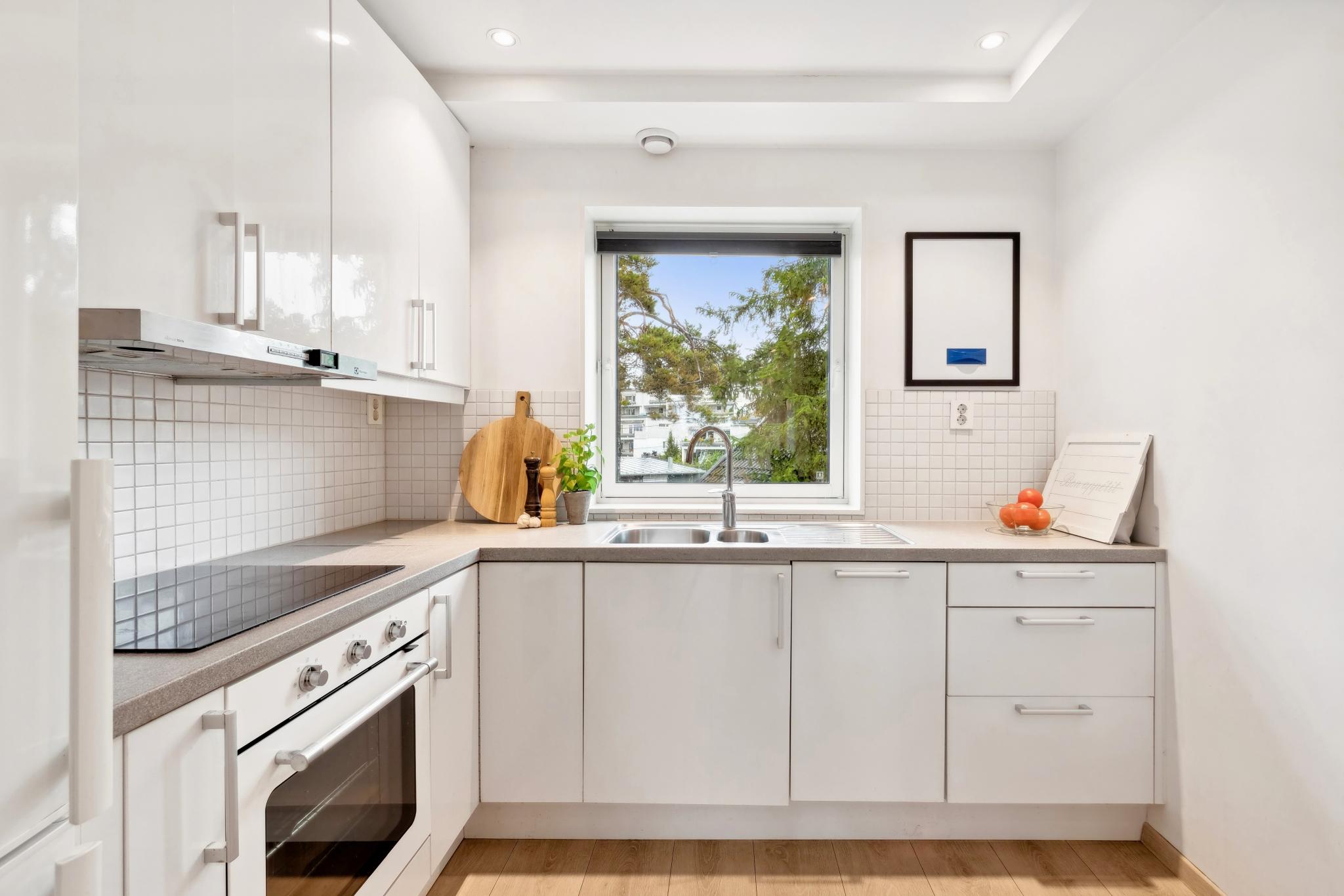 Kjøkkeninnredning med hvitevarer som stekeovn, oppvaskmaskin, kombiskap (kjøl/frys) og induksjonsplatetopp.
Det er montert komfyrvakt og automatisk stengekran.