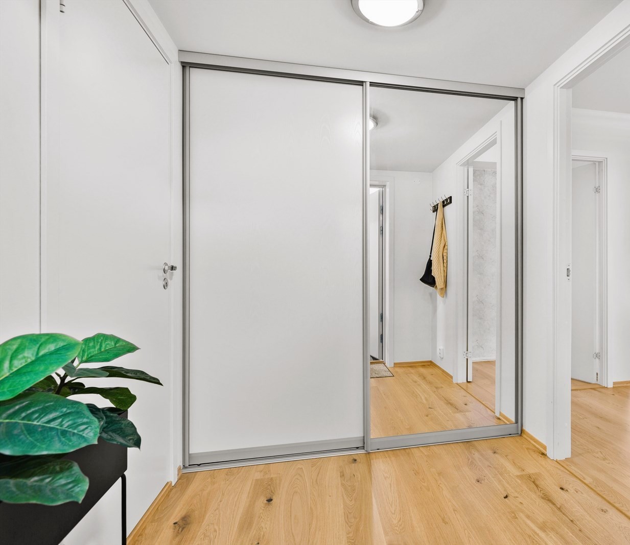Romslig entré med innebygd skyvedørsgarderobe og masse oppbevaringsplass