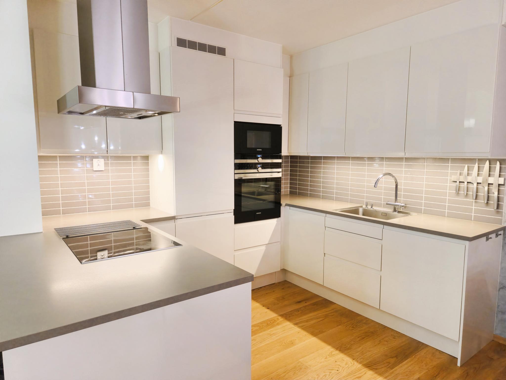 Lekkert og moderne kjøkken med integrerte hvitevarer (kjøleskap, platetopp, mikrobølgeovn, stekeovn, oppvaskmaskin)