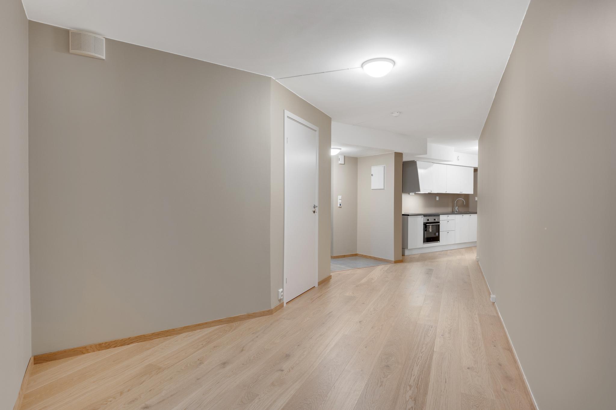 Stuen har gode møbleringsmuligheter med plass til både sofa- og TV-sone. Nøytrale overflater gjør det enkelt å sette sitt eget preg.