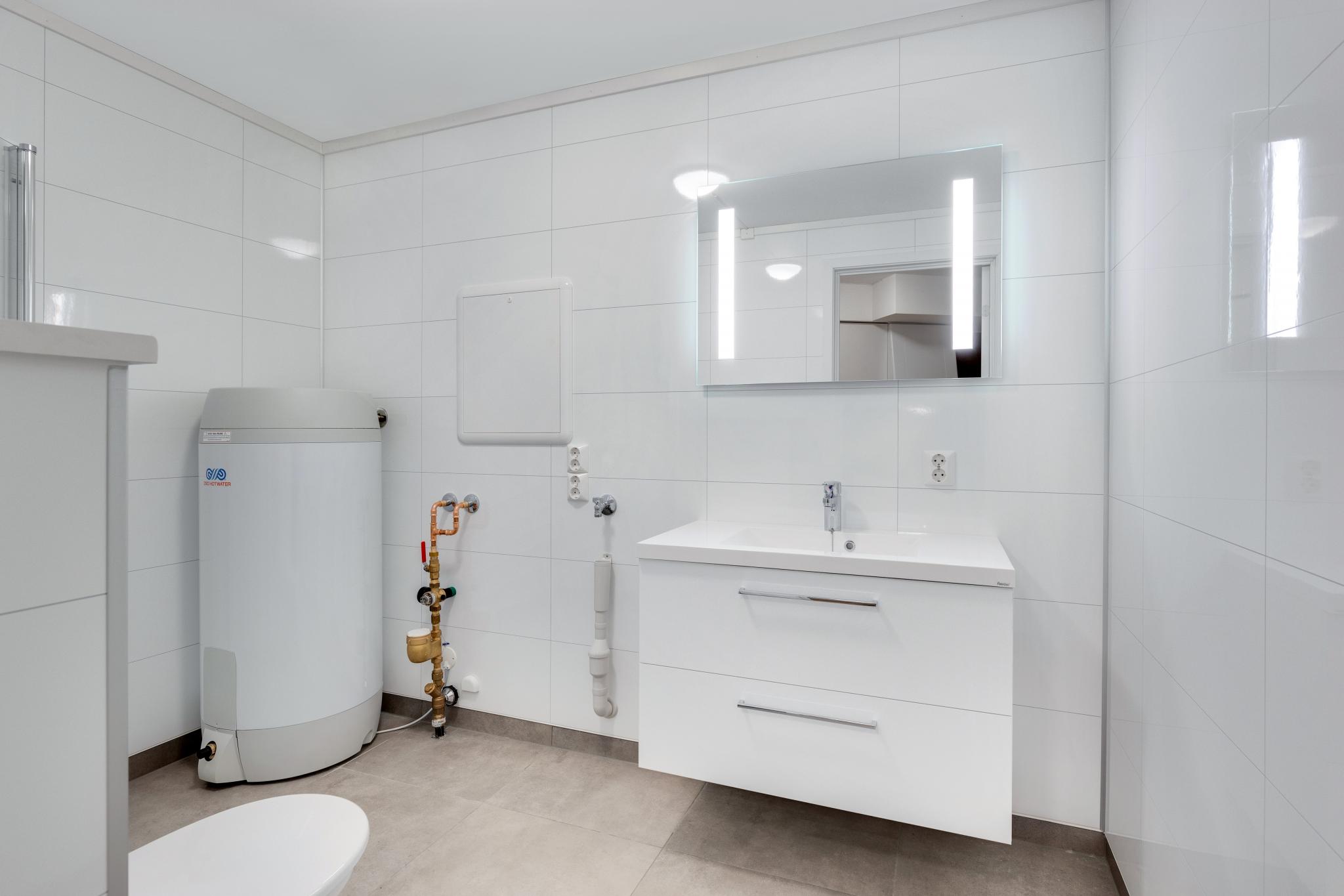 Delikat, flislagt bad med moderne uttrykk og gode materialvalg.