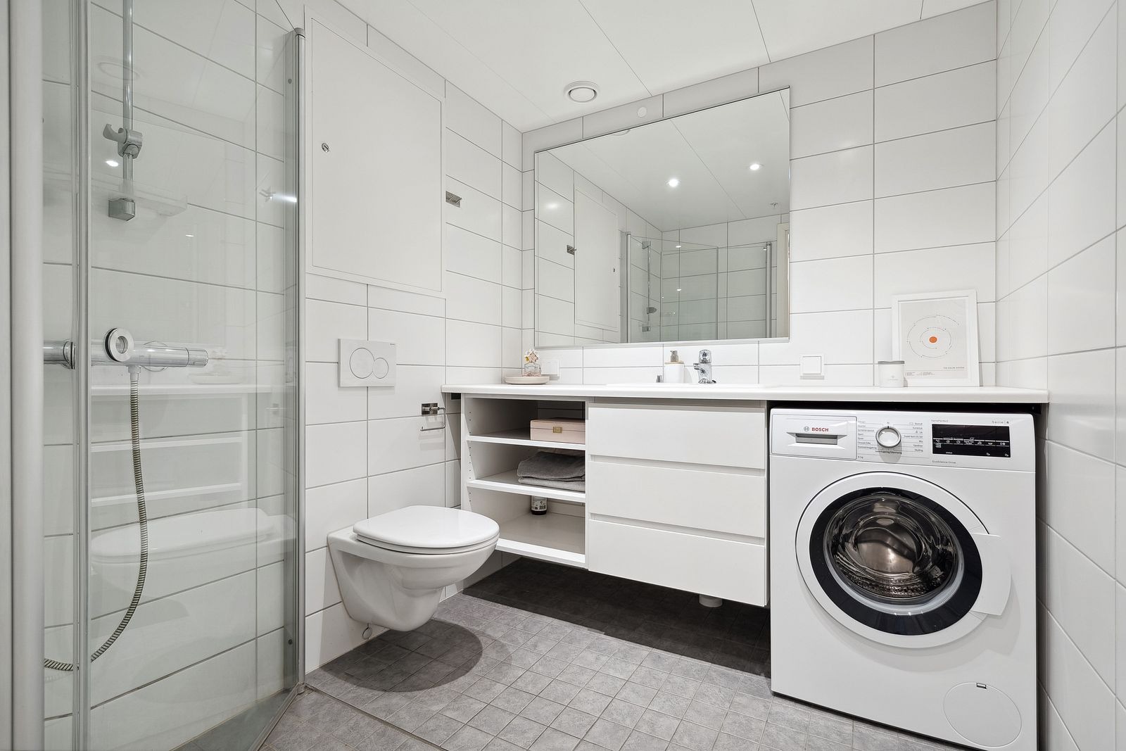 Badet er moderne og stilrent med dusjhjørne. Vaskemaskin medfølger leieavtalen.