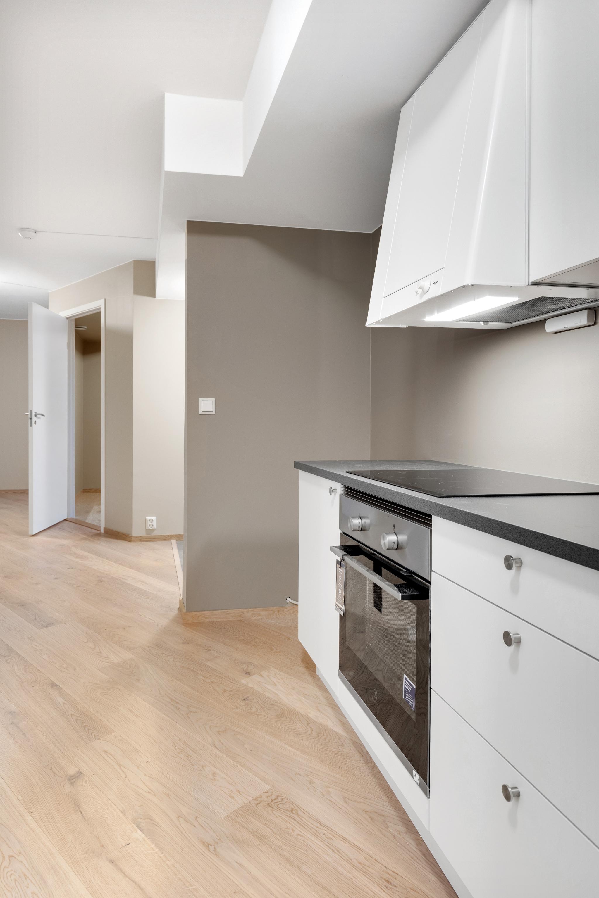 Kjøkkenet har en praktisk utforming med gode oppbevaringsmuligheter og integrerte løsninger.