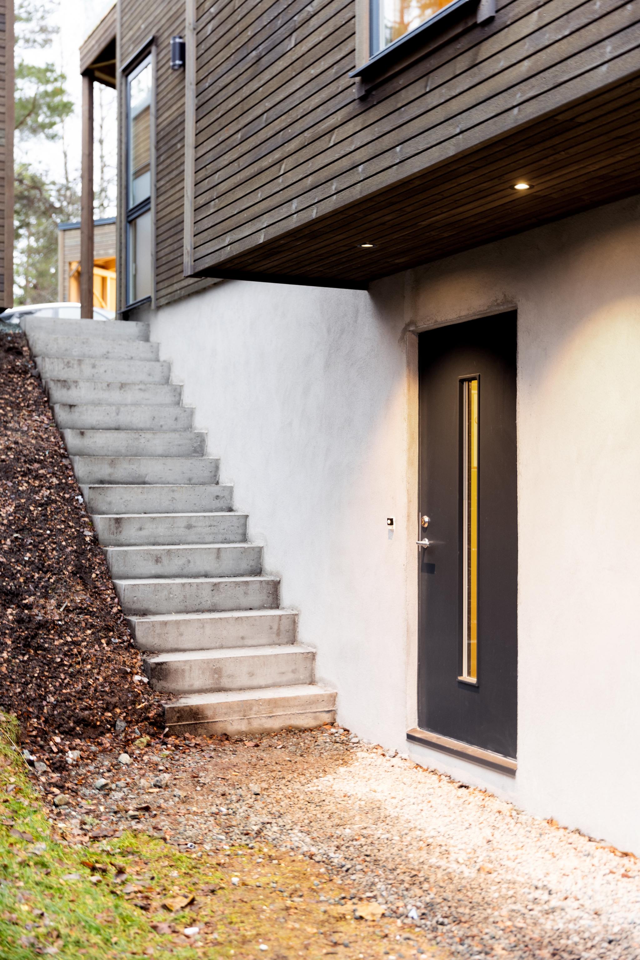 Inngangsparti. Det er i ettertid montert rekkverk og sykkelparkering ved trapp. 