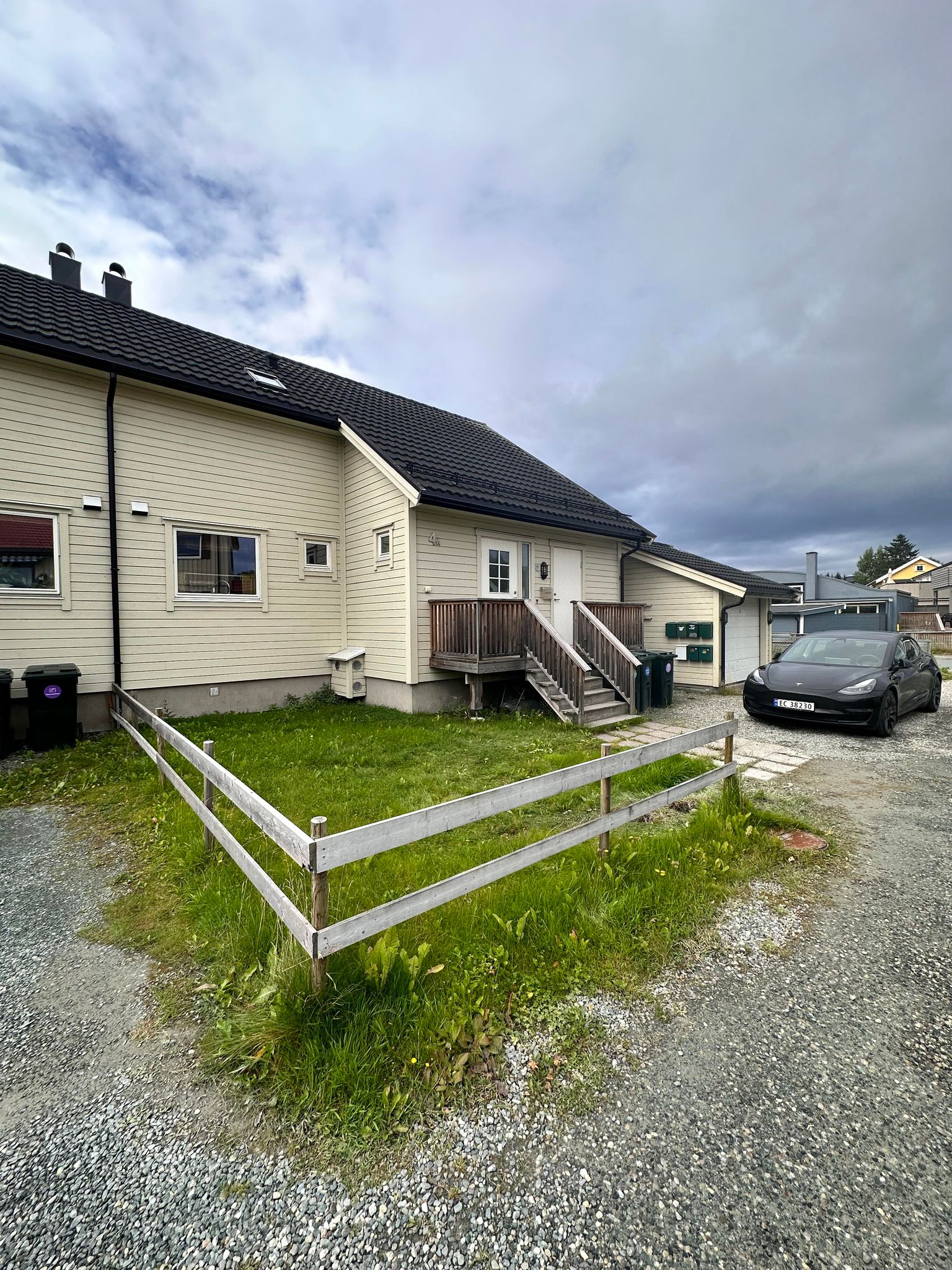 Utvendig bilde av halvparten. Garasje og biloppstillingsplass, samt hageflekk tilhører boligen.