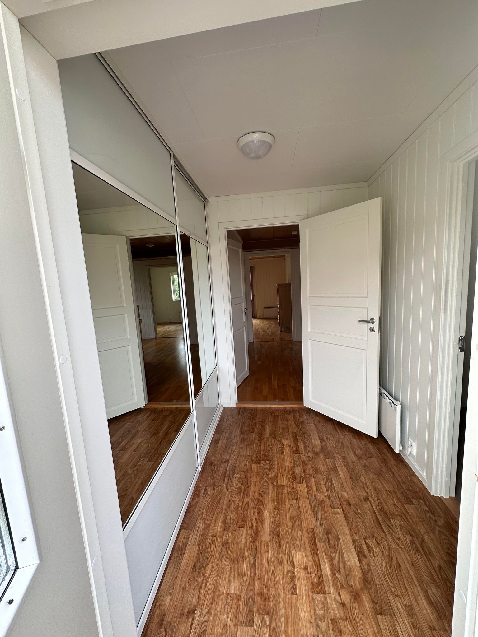 Entre med skyvedørsgarderobe. Bod til høyre.