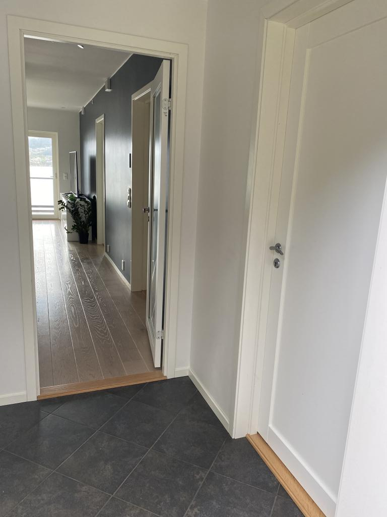 Bilde fra inngangsdør. Flislagt gang med varmekabler, skyvedørsgarderobe medfølger.