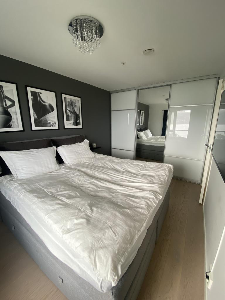 Hovedsoverom med skyvedørsgarderobe og sjøutsikt. 