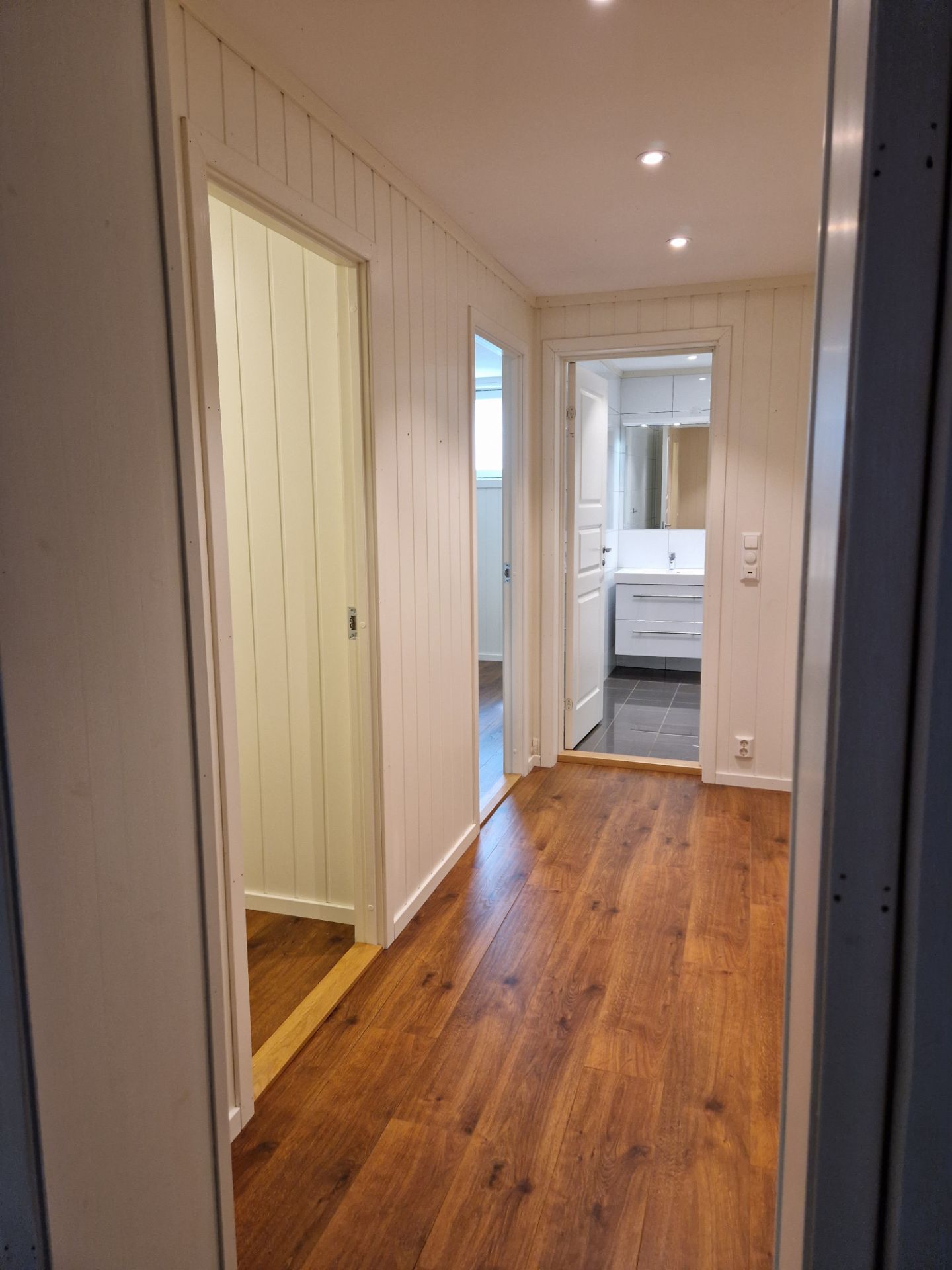 Gang med ny skyvedørsgarderobe og nylagte fliser med varmekabler