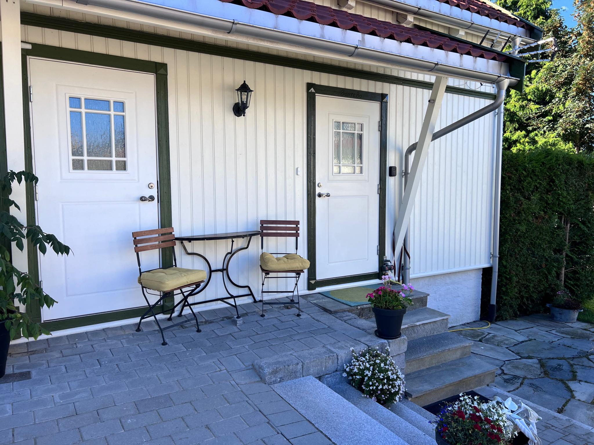Inngangs dør til høyre. Dør til venstre er bod tilhørende hovedhuset.Stor terrasse på framsiden (bak tujahekken)