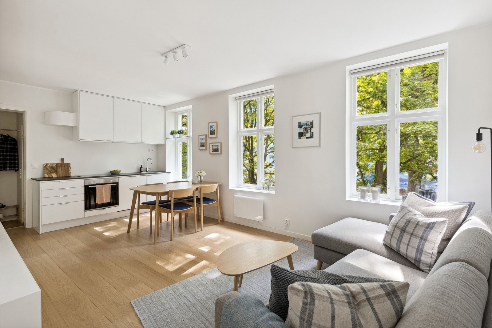 Moderne kjøkken med integrert oppvaskmaskin, stekeovn, platetopp og stort kombiskap.