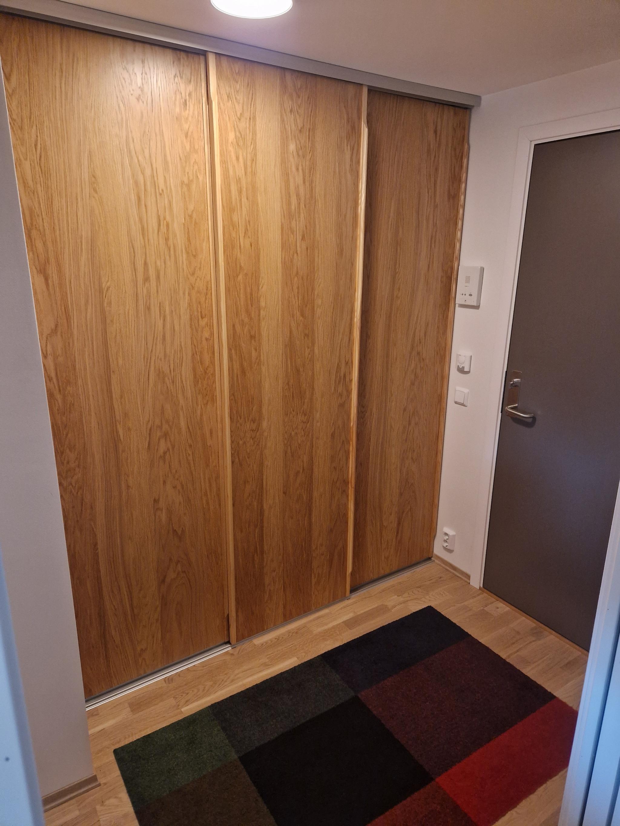 Gang med stor skyvedørsgarderobe i heltre, speil kommer på den ene døra