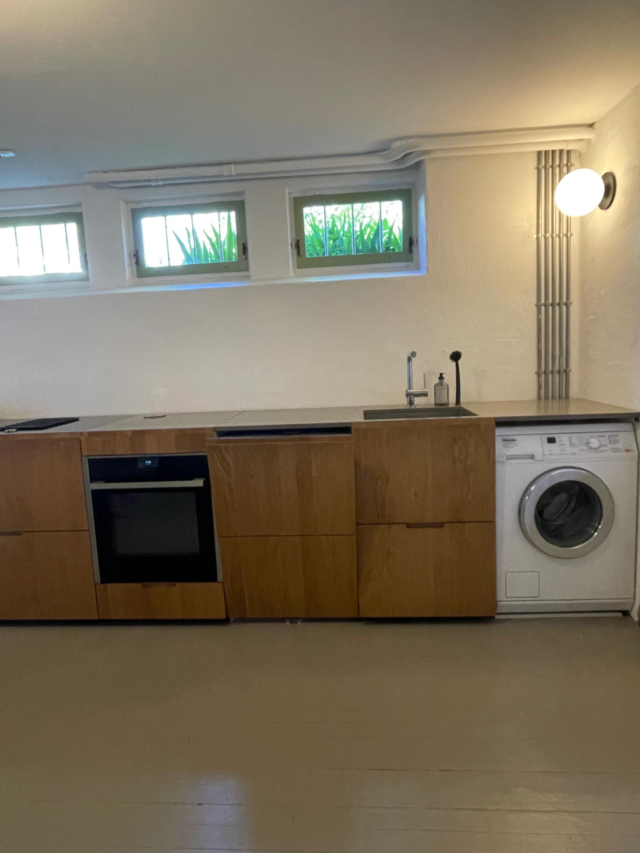 Kjøkken med kjøleskuffer fra Norcool, stekeovn og koketopp med integrert ventilator fra Neff. Oppvaskmaskin og vaskemaskin.