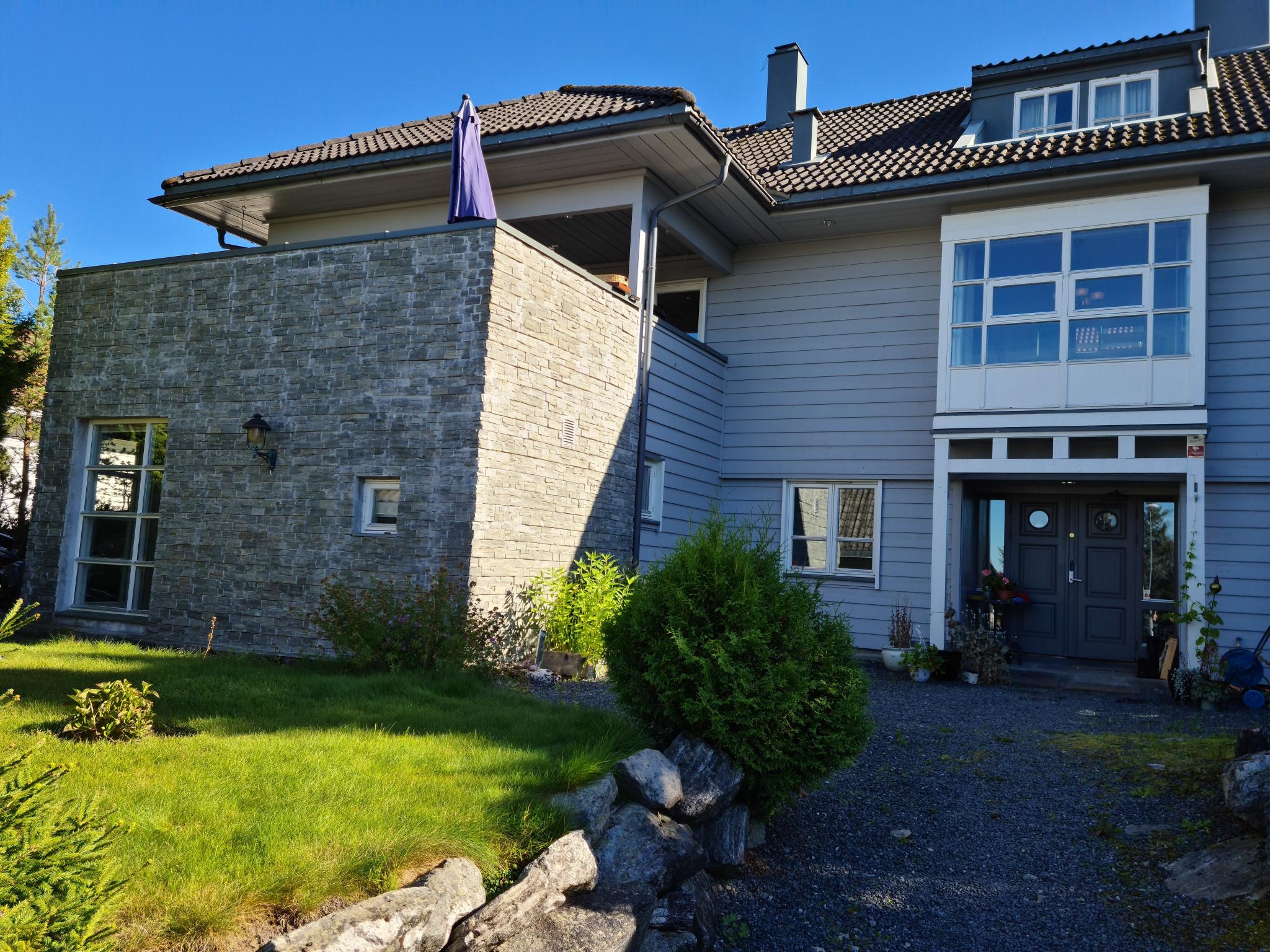 Framside på enebolig. Inngang sokkelleilighet til venstre på muren