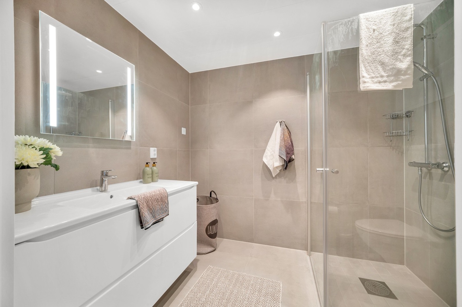 Lekkert og moderne flislagt bad med varme i gulv, downlights i himling og god plass til vaskemaskin. Sistnevnte kan medfølge i leien.