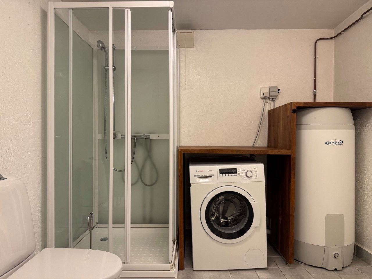 bad med vaskemaskin og dusj kabinett