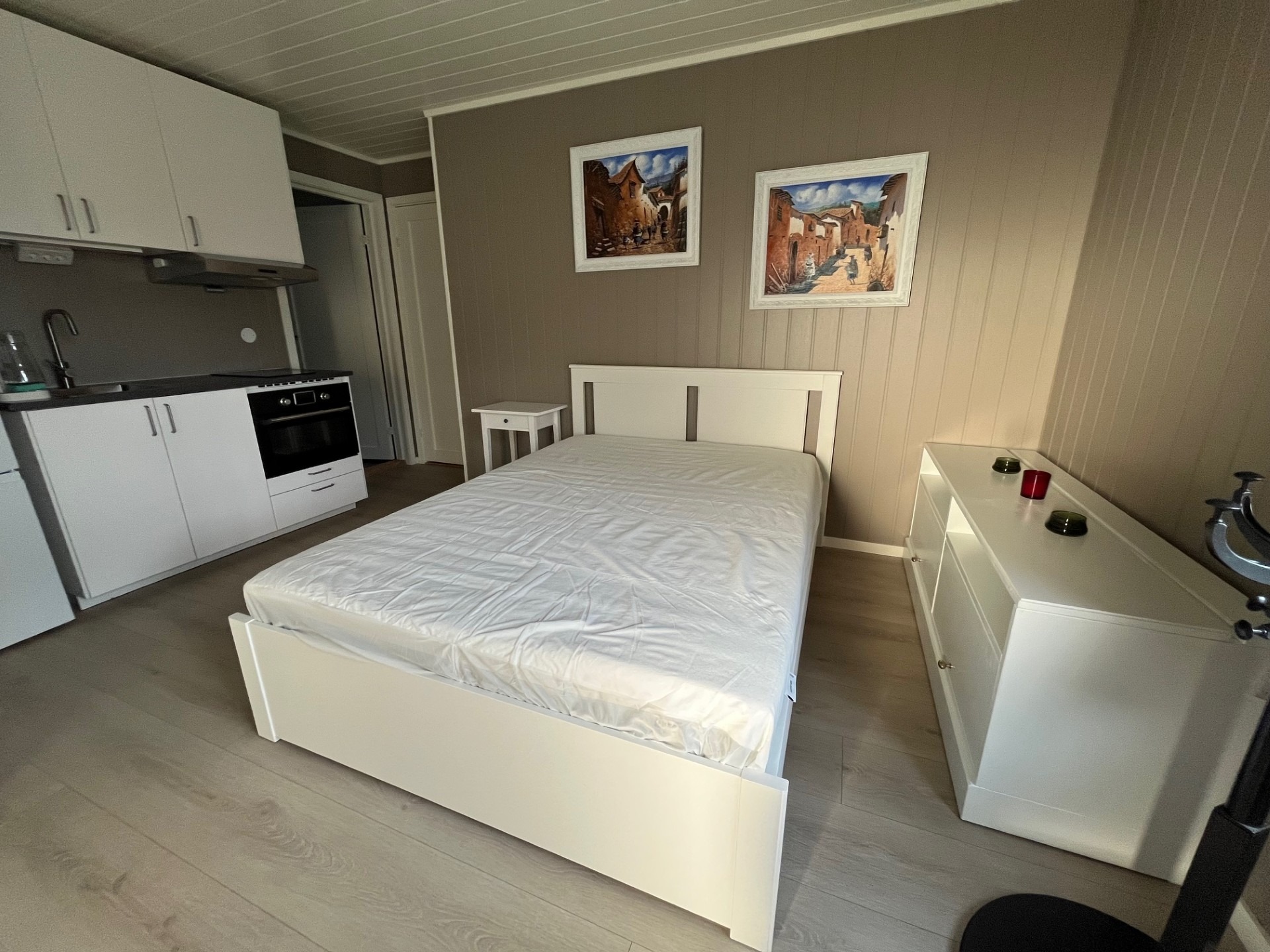 Romslig soverom utstyrt med en 140x200 cm seng, nattbord, kommoder, speil, gardiner, TV-hylle