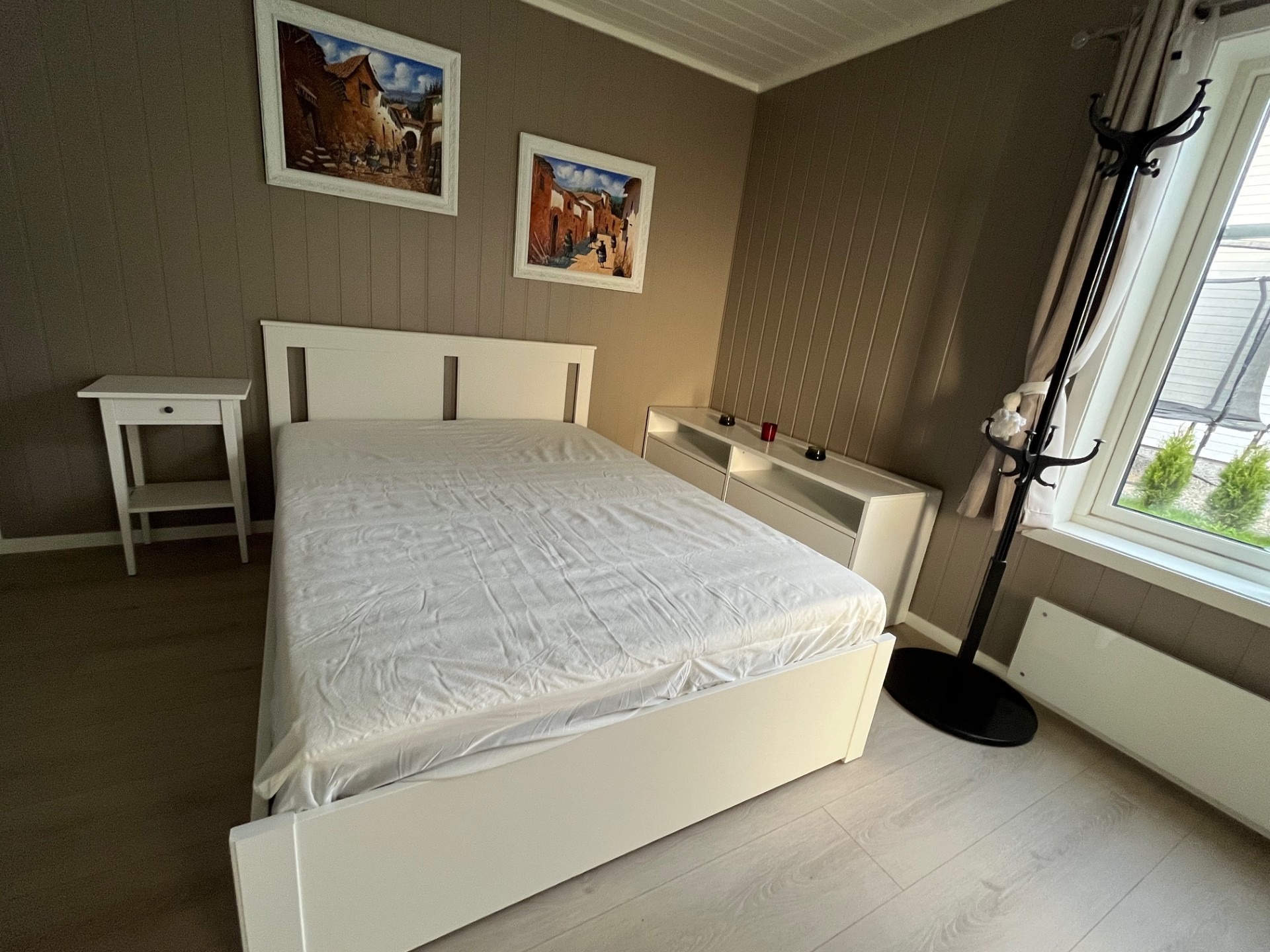 Romslig soverom utstyrt med en 140x200 cm seng, nattbord, kommoder, speil, gardiner, klesstativ, TV-hylle