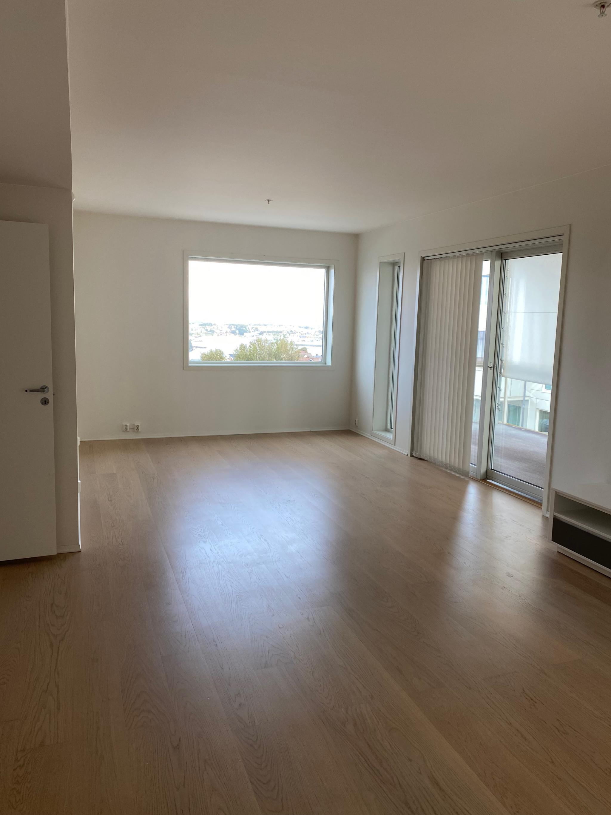 Stue, vindu mot øst, utsikt over byfjorden, skyvedør ut mot den ene terrassen.