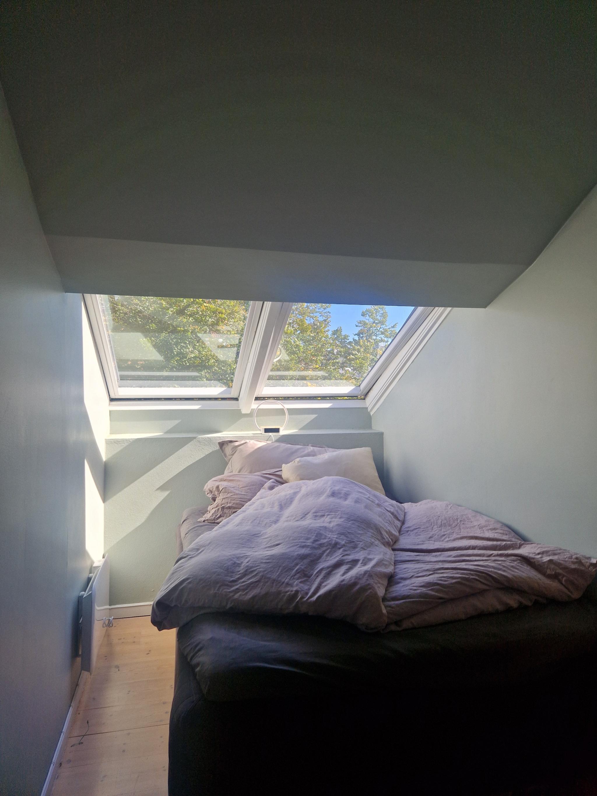 Soverom 1 med lystette gardiner og klesskap.