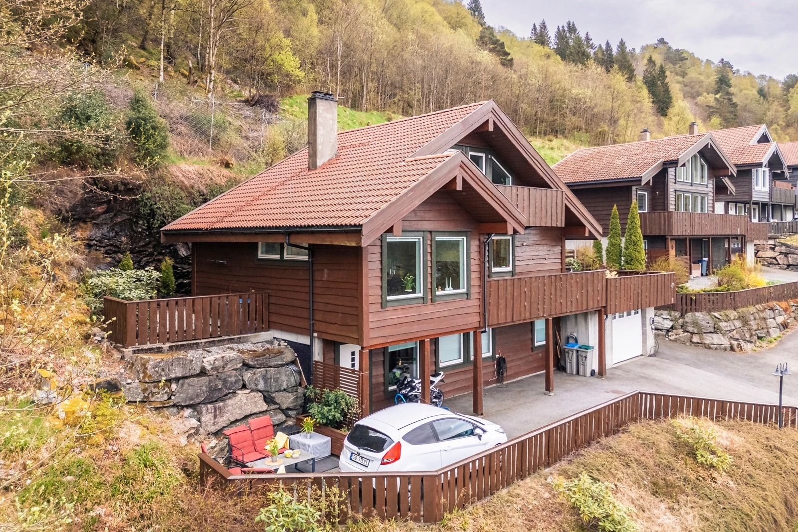 Plass til sittegruppe og parkering av biler utenfor leiligheten i nederste etasje. 
