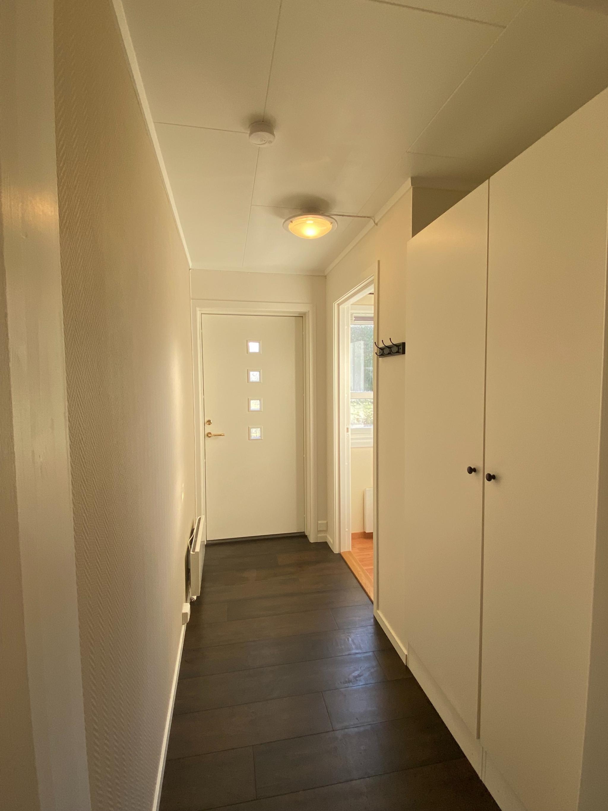 Entré. Leies ut med garderobeskap, panelovn og knagg.