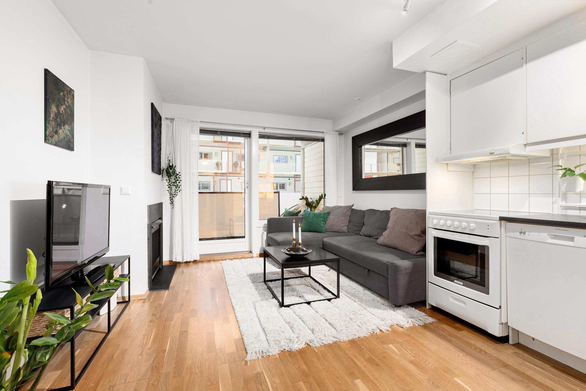 Stue med åpen kjøkkenløsning og utgang til balkong