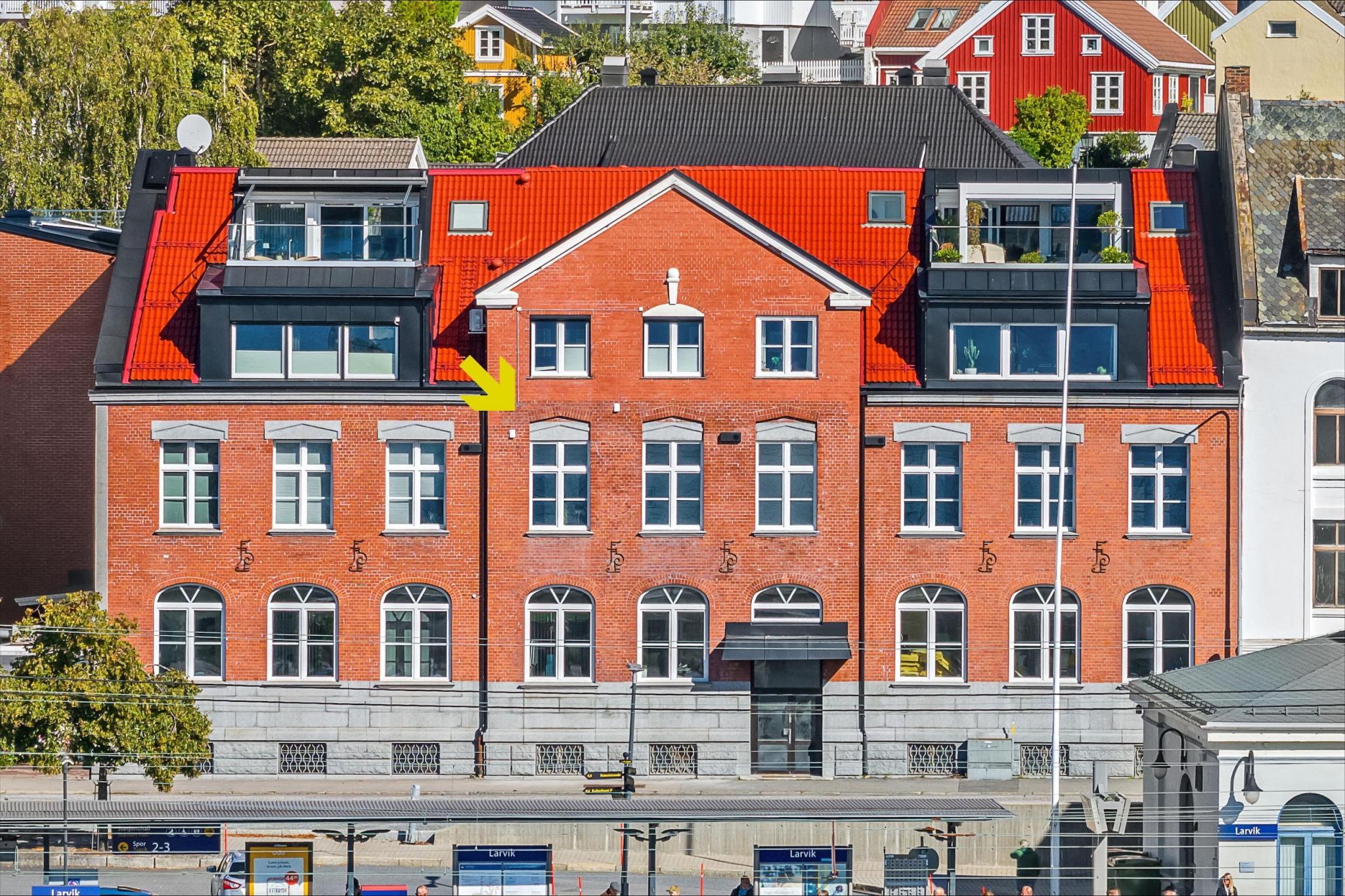 Pil viser leiligheten, de tre midterste vinduene tilhører leiligheten