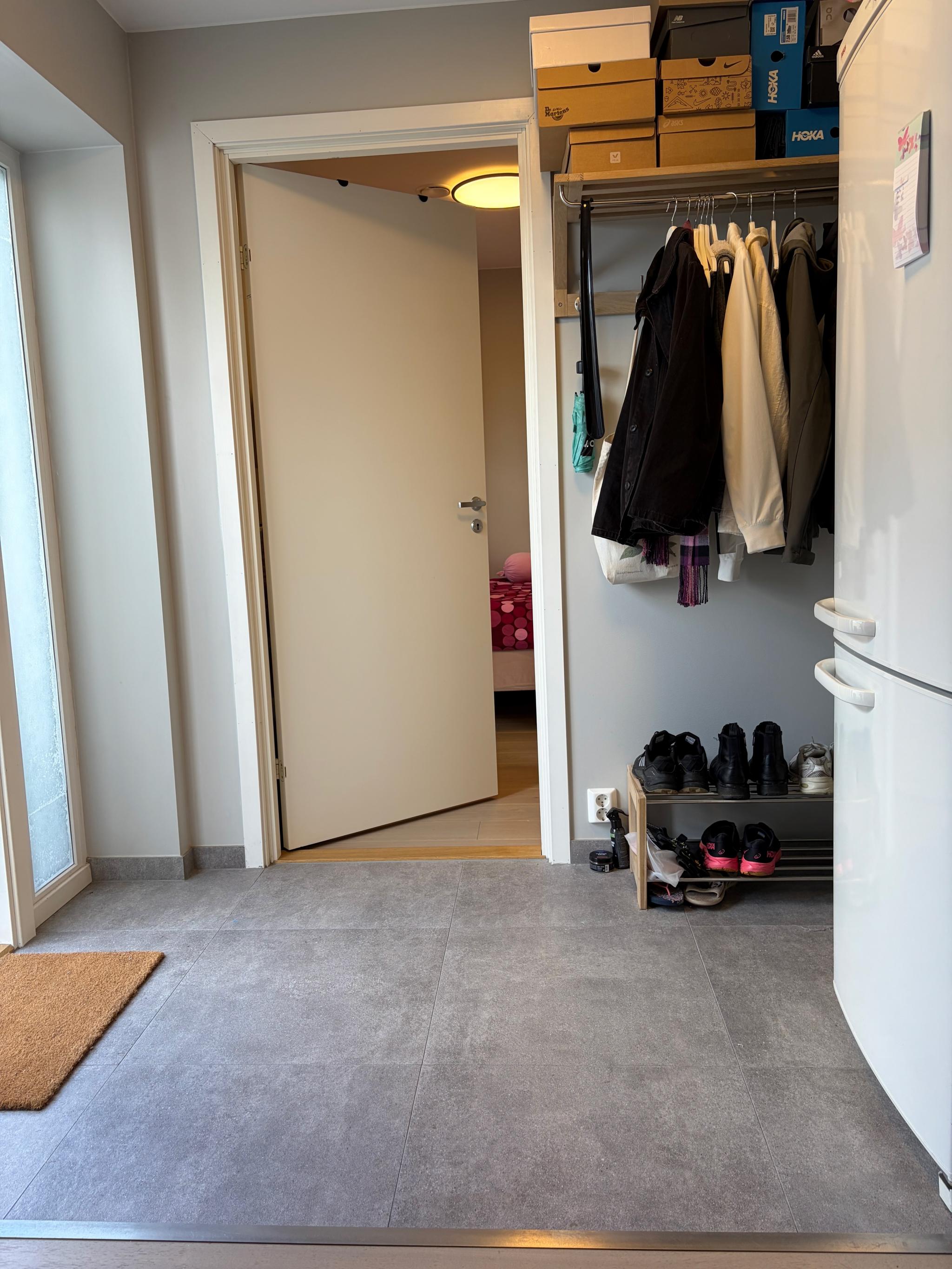 Flislagt entre med varmekabler. God plass til både sko og jakker.